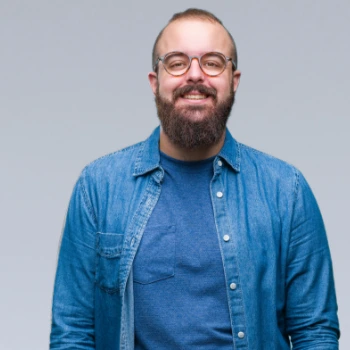 Caucasian man with glasses smiling at the camera